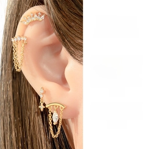 Detailed view of gold titanium steel chain earrings set with star and crown studs