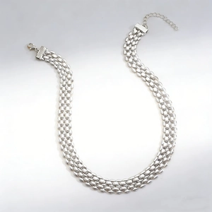 Macro shot of silver multi-layered chain necklace featuring lobster clasp and extension