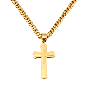 Detailed view of the layered gold cross pendant and polished Cuban link chain