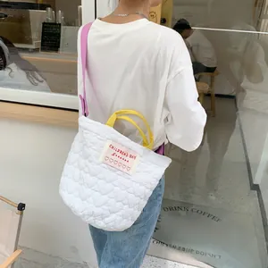 Vue détaillée d'un sac à bandoulière matelassé blanc avec des lanières violettes