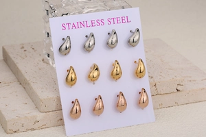 Macro view of water-drop stainless steel stud earring set in gold, silver, and rose gold