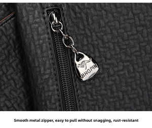 Macro detail of a silver kangaroo-logo zipper on textured black pebble leather
