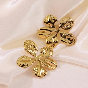 Elegant gold flower stud earrings with hammered texture on cream silk fabric
