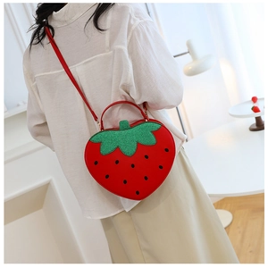 Side view of a creative strawberry shaped crossbody bag with glitter leaf detail and strap