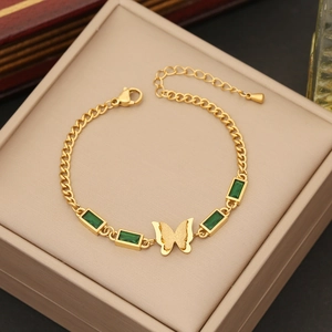 Golden butterfly bracelet with green gemstones presented in a premium jewelry gift box