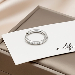 Macro view of silver hoop earrings with clear crystals on a premium display box