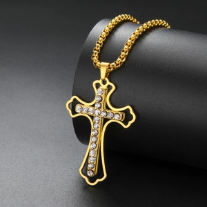 Macro shot of gold cross pendant with crystal rhinestones on a black stand