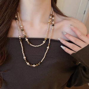 Primo piano della collana a doppio strato con perle beige e pietre occhio di tigre