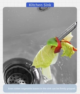 Drain cleaning claw tool grabbing food waste from a kitchen sink drain pipe