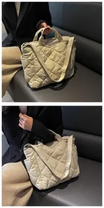 Close-up of quilted beige tote bag showing diamond stitching and side pocket detail