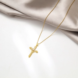 Luxurious gold hollow sword cross pendant necklace with zircon inlay on silk background
