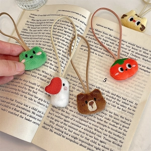 Detailed view of plush animal charms featuring bear and duck on a vintage book