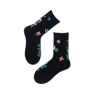 Detail of black cotton mid-calf socks with floral and butterfly embroidery patterns