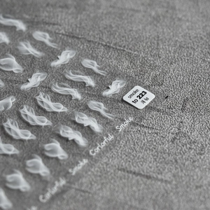 Macro shot of thin smoke patterns nail stickers with model to 223 on grey fabric
