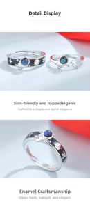 Close-up of 925 sterling silver astronaut couple rings with blue starry glaze