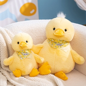 Cute yellow duck plush toy set with floral summer scarf on white soft sofa