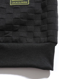 Macro shot of men's slim fit black knit sweater with textured checkered pattern and ribbed hem
