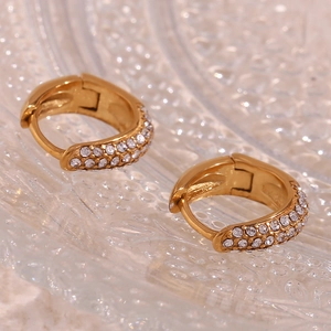Macro detail of gold-plated mini pear earrings with triple-row micro-pave crystals