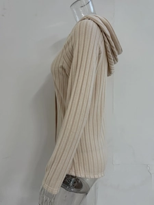 Dettaglio della trama a costine sulla felpa con cappuccio beige a maniche lunghe
