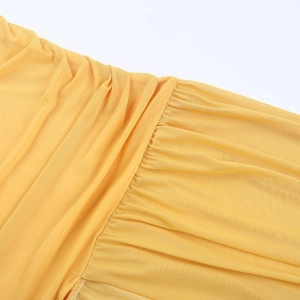 Detailed macro shot of yellow mesh fabric with intricate pleated design and fine texture