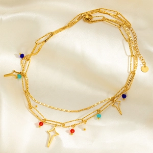 Détail d'un collier doré triple rang avec étoiles et perles de couleur sur soie
