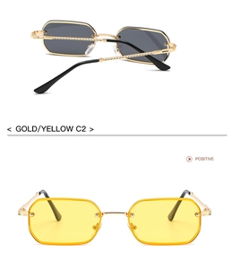 Detail of gold metal sunglasses with spiral twisted temples and yellow tinted lenses