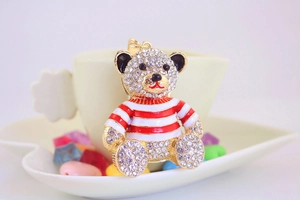 Close-up of a sparkling bear keychain with red and white stripes and inlaid rhinestones