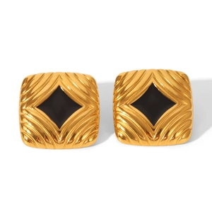 Macro detail of gold square earrings with wavy texture and black diamond-shaped stones