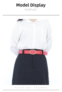 Close-up of a stylish red PU leather belt with an oval metal buckle on a black dress