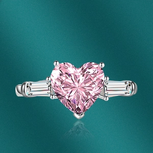 Detailed macro view of heart-cut pink zircon ring with rectangular side stones and silver band