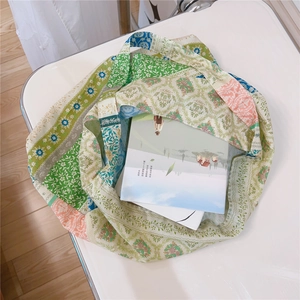 Close-up of floral patchwork canvas tote bag showing spacious interior with books inside