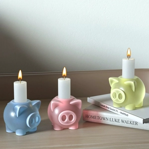 Trois bougeoirs mignons en forme de cochon en silicone avec des bougies allumées