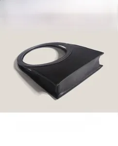 Detailed side view of black minimalist handbag with integrated circular hollow handle