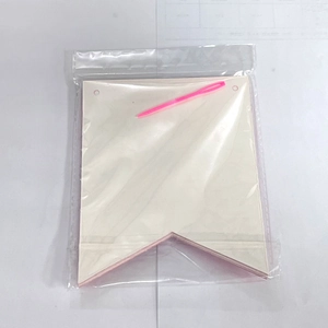 DIY dog birthday banner kit with blank beige paper flags and pink plastic needle tool