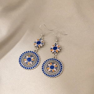 Close-up of bohemian enamel mandala earrings with blue and orange floral details
