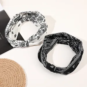 Detail showing paisley knot headbands in black and white styles for yoga and sports