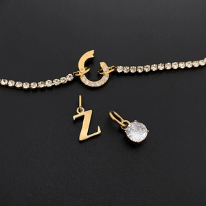 Detailed view of gold titanium steel rhinestone letter Z and crystal pendants.