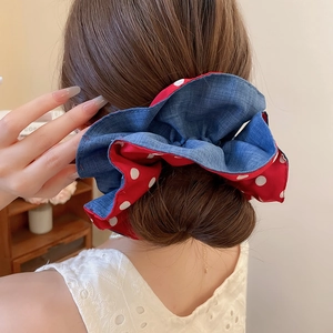Close-up of a double-layer polka dot scrunchie in denim blue and red on a ponytail