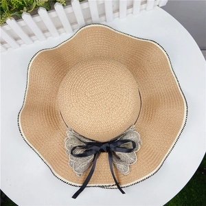 Straw sun hat with wavy brim, lace butterfly bow, and black-white contrast stitching