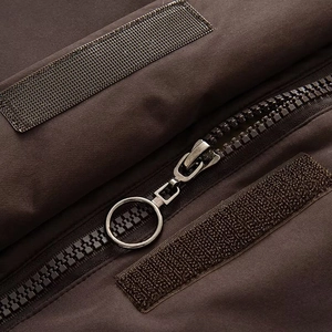 Détail de la veste outdoor marron foncé avec fermeture éclair à anneau et velcro