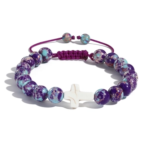 Bracciale intrecciato pasquale con perline viola e blu e ciondolo a croce bianca su sfondo bianco