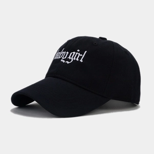 Close-up of white gothic baby girl embroidery on a classic black cotton baseball cap