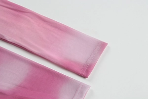 Detail of pink gradient mesh fabric with fine double-needle stitching on the hemline