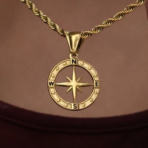 Gold compass pendant necklace with north star engraving on a delicate rope chain