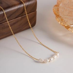 Macro shot of fine 18K gold-plated chain featuring five natural freshwater pearls