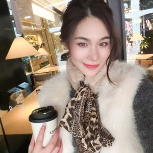 Detail of leopard print silk scarf with cream faux fur vest for winter warmth