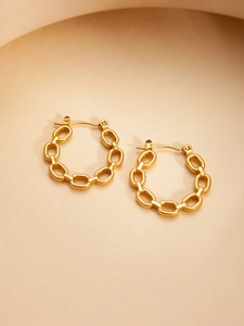 Macro view of gold-toned chain link hoop earrings with a polished luxury finish