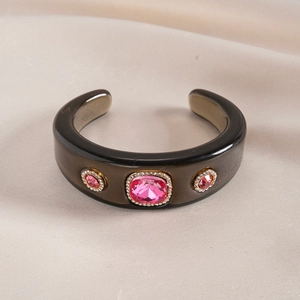 Macro shot of resin cuff bracelet with pink crystal inlay and gold accents