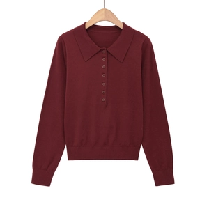 Dettaglio della maglia polo in maglia bordeaux a maniche lunghe con sette bottoni e polsini