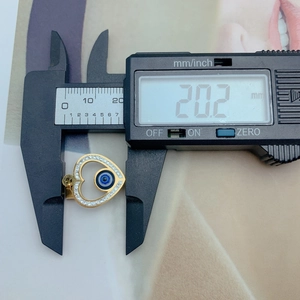 Digital caliper measuring the 20.2mm width of the gold heart evil eye pendant charm